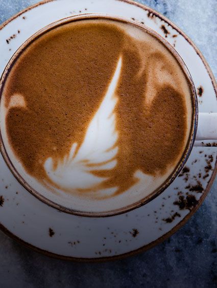 overhead close up of a cappuccino in white cup and saucer